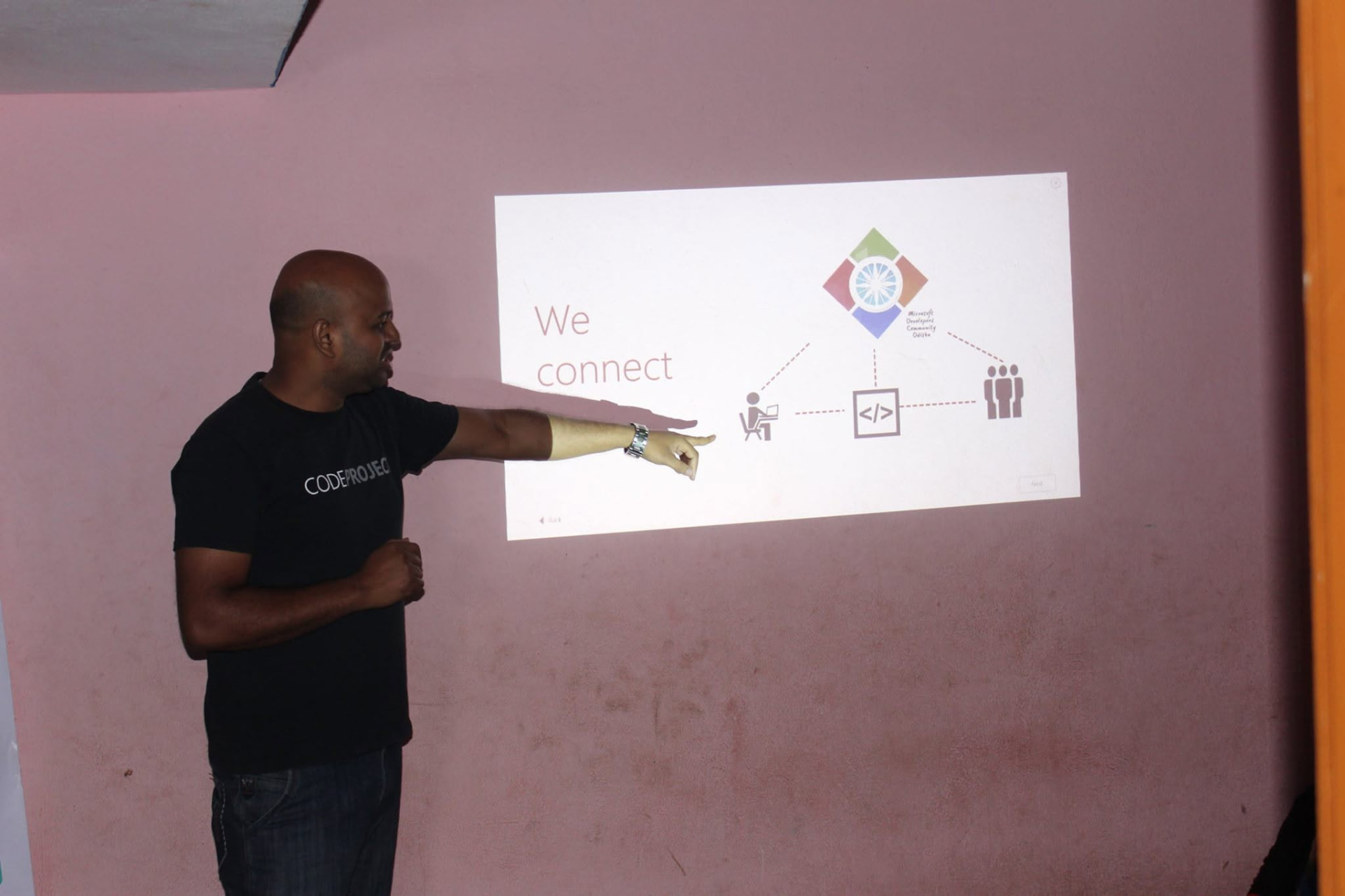 Suvendu Shekhar Giri pointing at a projected slide reading 'We connect' during a school community coding session