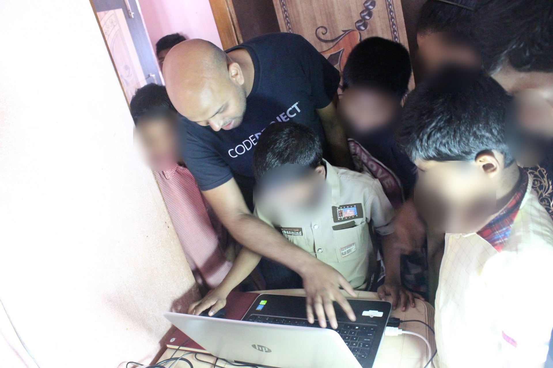 Suvendu Shekhar Giri teaching children the basics of coding on a laptop at an orphanage school in 2015