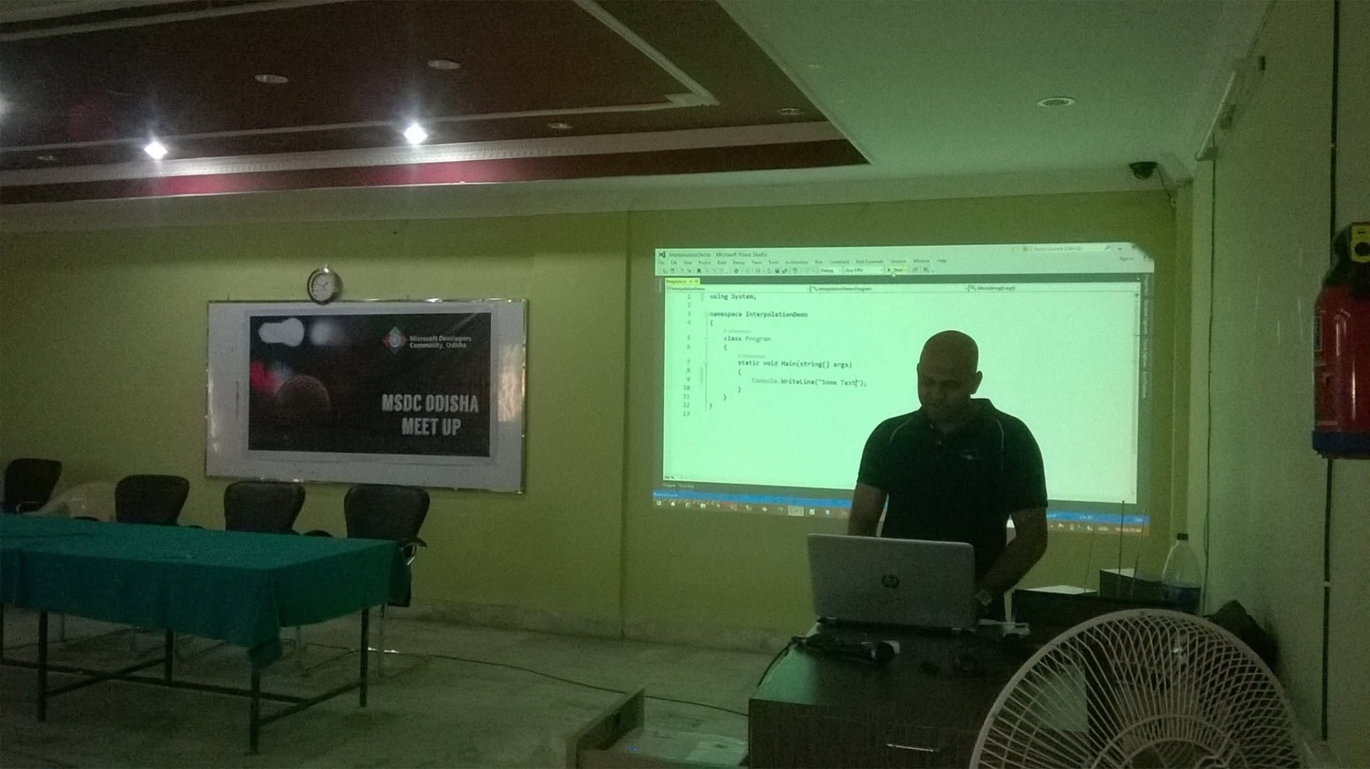 Suvendu Shekhar Giri demonstrating C# 6.0 code in Visual Studio on a projector screen at an MSDC Odisha meetup at USBM